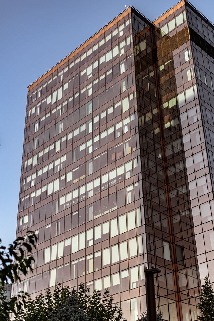 Tall modern glass skyscraper against a clear sky, symbolizing urban architecture.