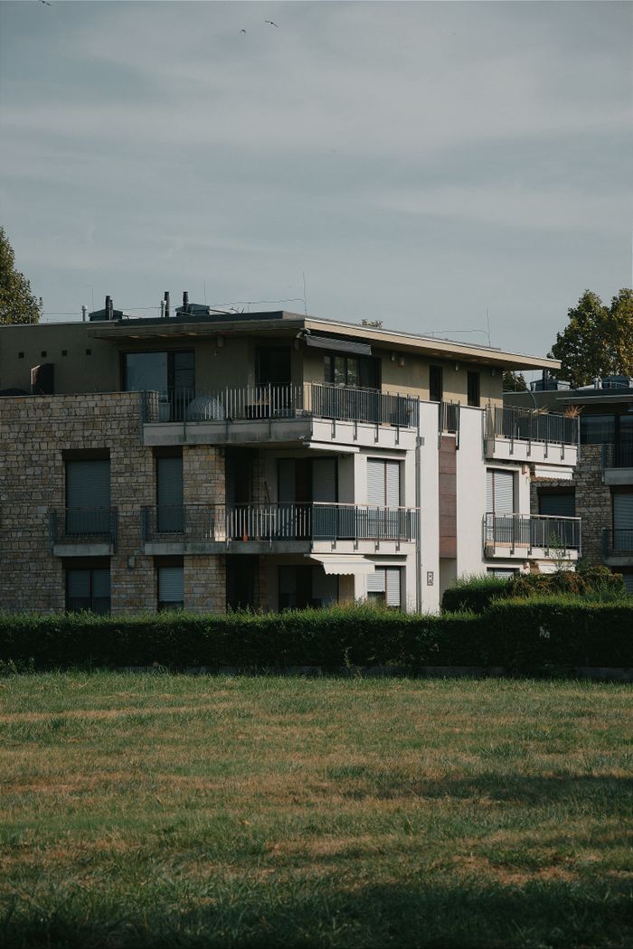 A contemporary apartment building set amidst greenery in Hungary, showcasing modern architecture.